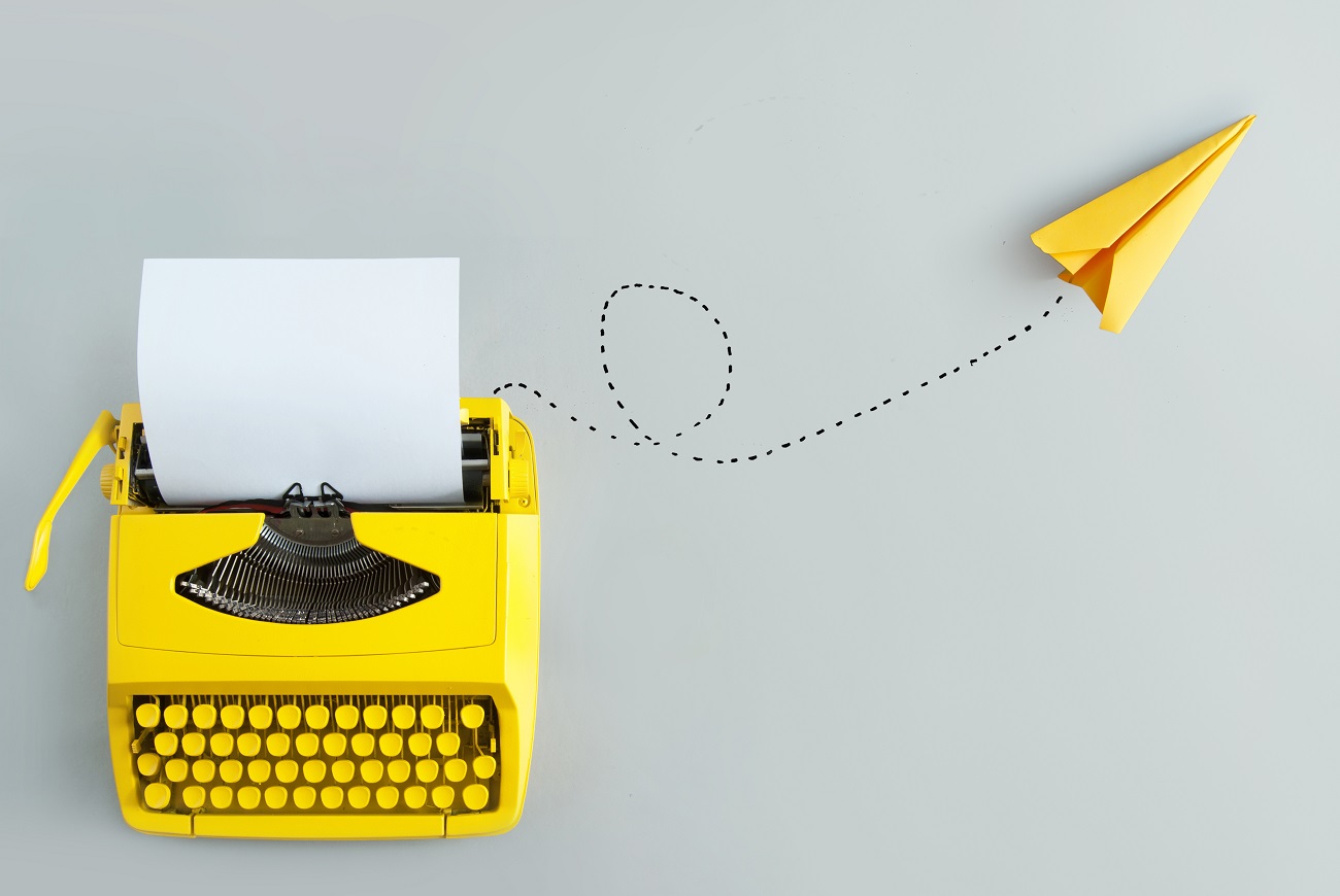 Retro-Schreibmaschine mit gelbem Papierflieger, Inspiration und Innovation